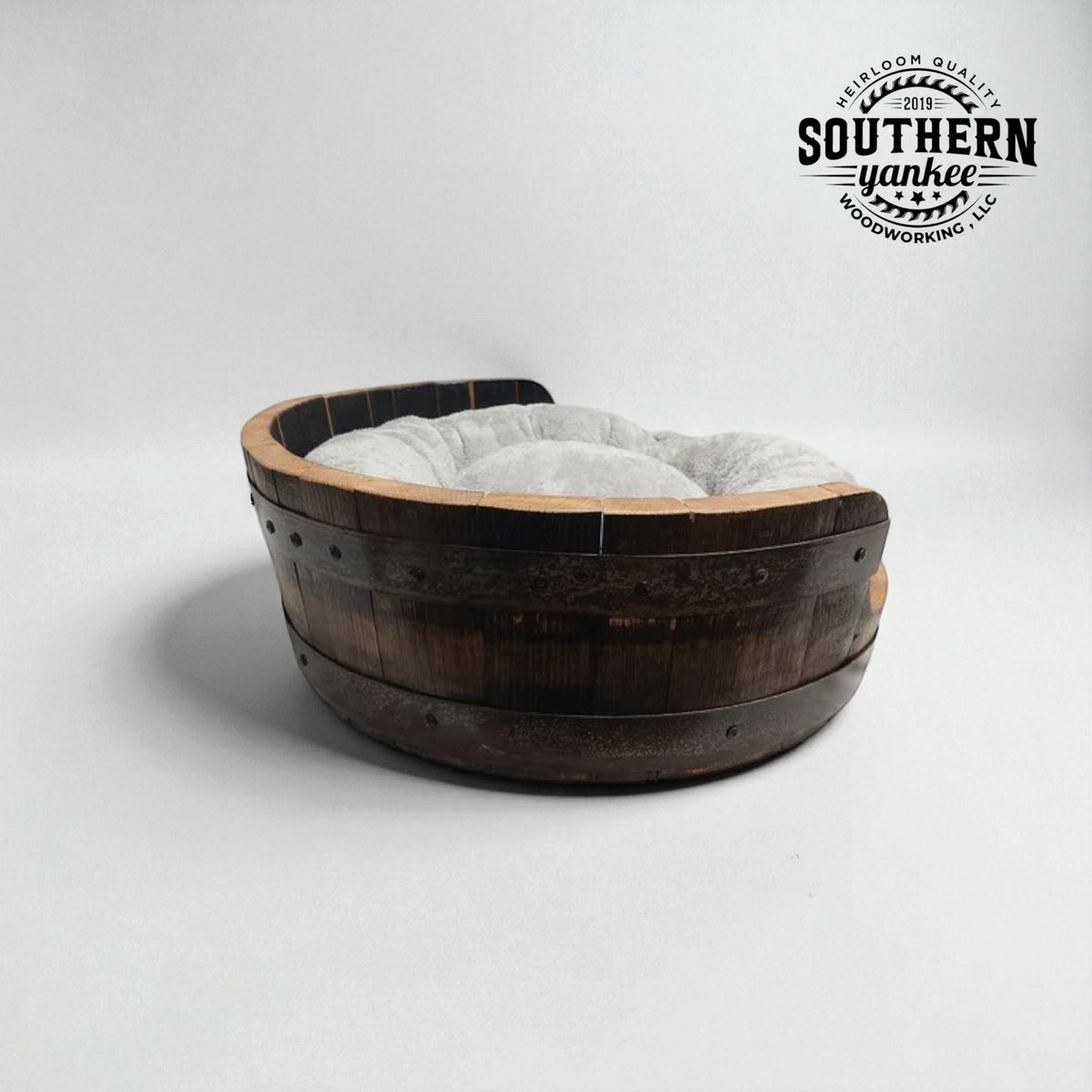 Wooden barrel-shaped pet bed with a fluffy cushion on a white background, branded with 'Southern Yankee'.